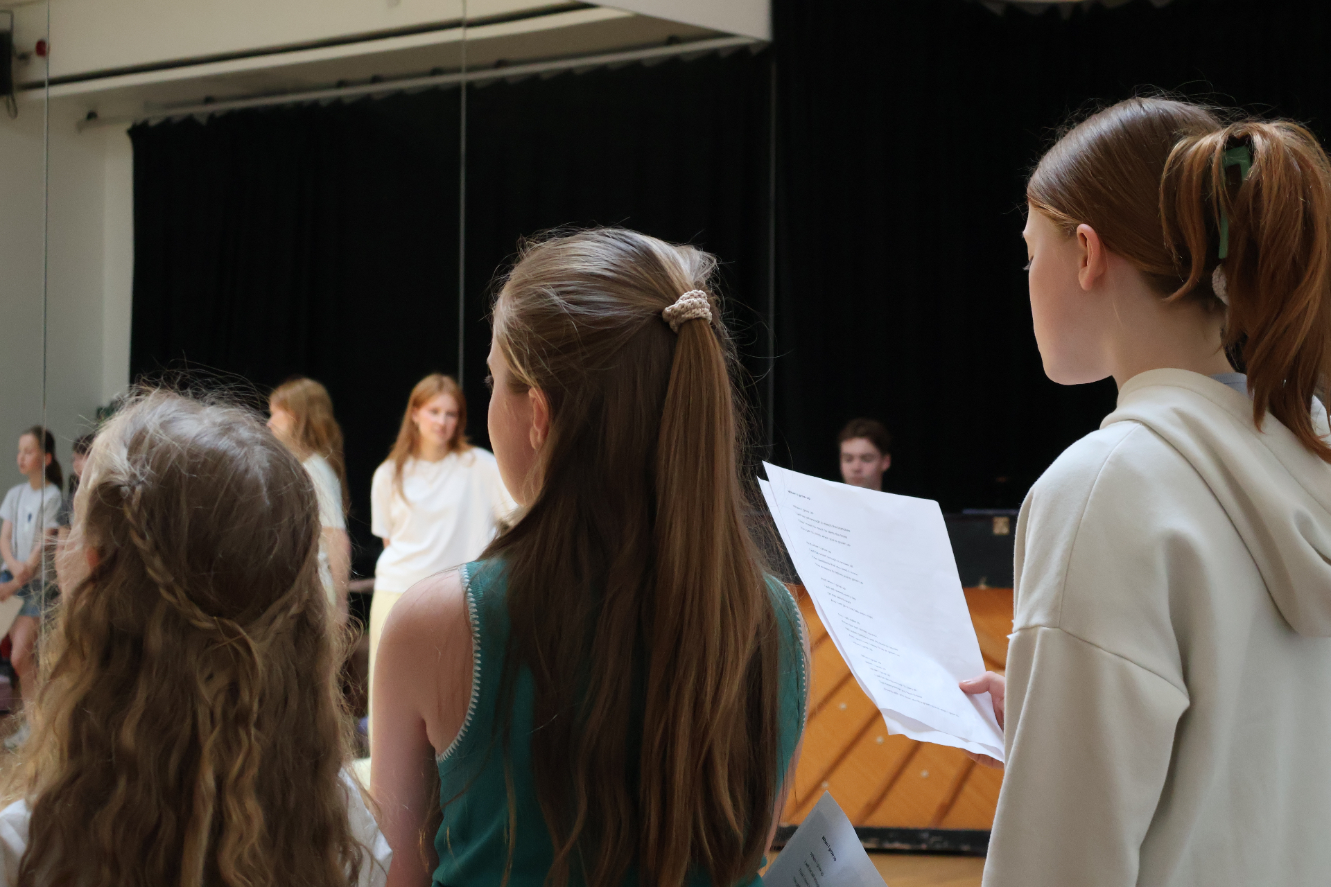 Students following lyrics during a ReAct singing rehearsal