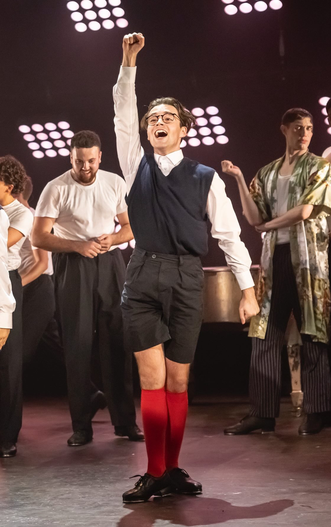 A ReAct tutor raising a fist on stage in a celebratory performance moment
